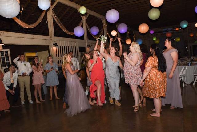 Guests dancing under colored lanterns in the barn